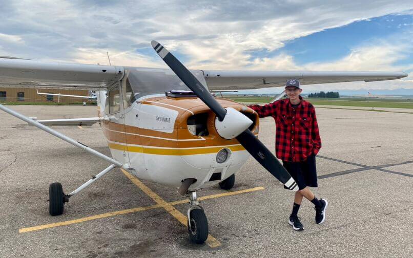 Derek posing next to an airplane.