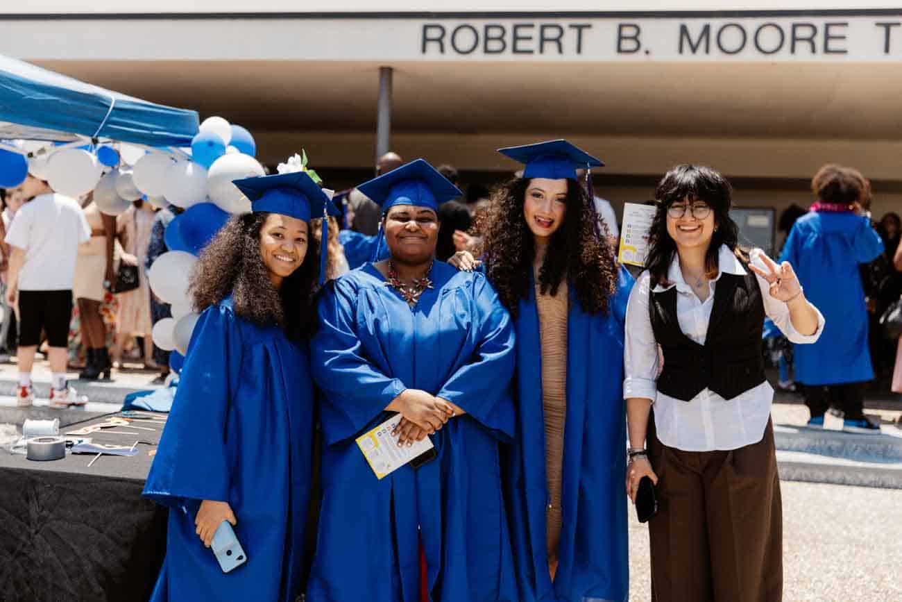 students with teacher at graduation