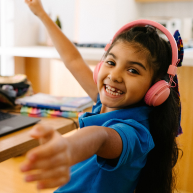 Elementary student wearing a pink pair of headphones